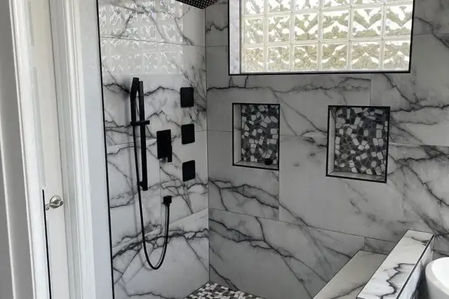 Walk-in shower in a San Antonio bathroom remodel with marble-look porcelain walls, matte black fixtures and a glass block window